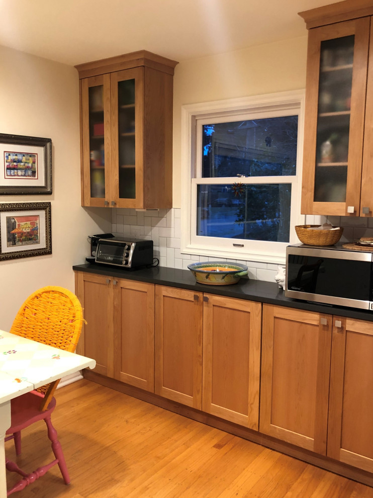Inspiration for a mid-sized transitional galley medium tone wood floor, brown floor and exposed beam eat-in kitchen remodel in Seattle with an undermount sink, shaker cabinets, medium tone wood cabinets, quartz countertops, white backsplash, subway tile backsplash, stainless steel appliances, a peninsula and gray countertops