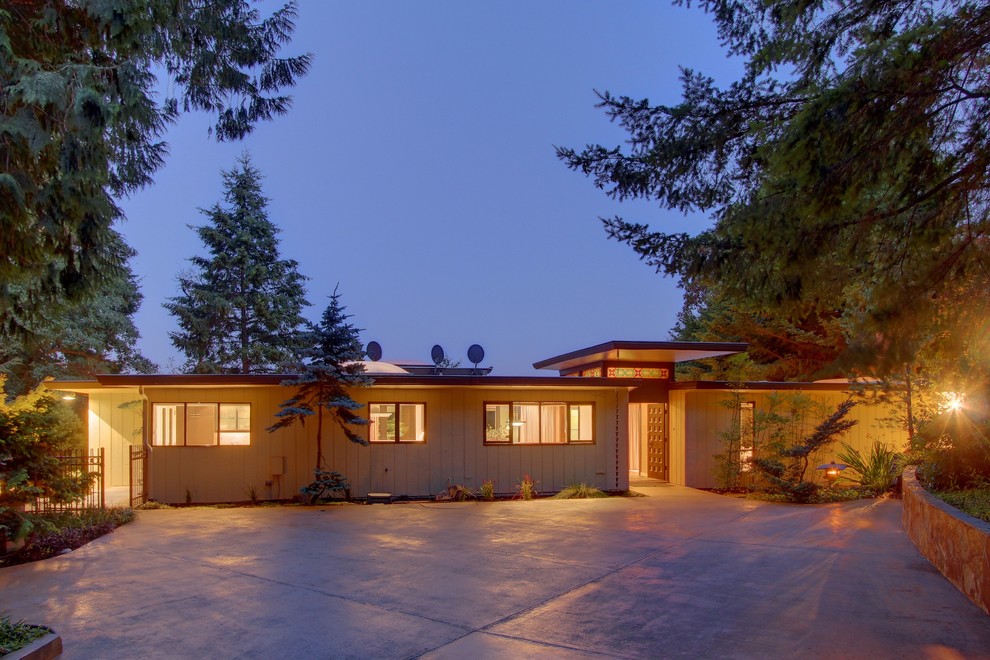 This is an example of a midcentury two-storey exterior in Seattle with wood siding.