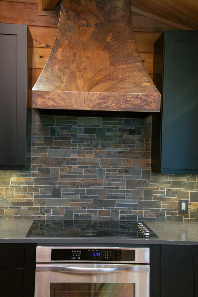 Open concept kitchen - large rustic l-shaped light wood floor open concept kitchen idea in Portland with shaker cabinets, black cabinets, stainless steel appliances and an island