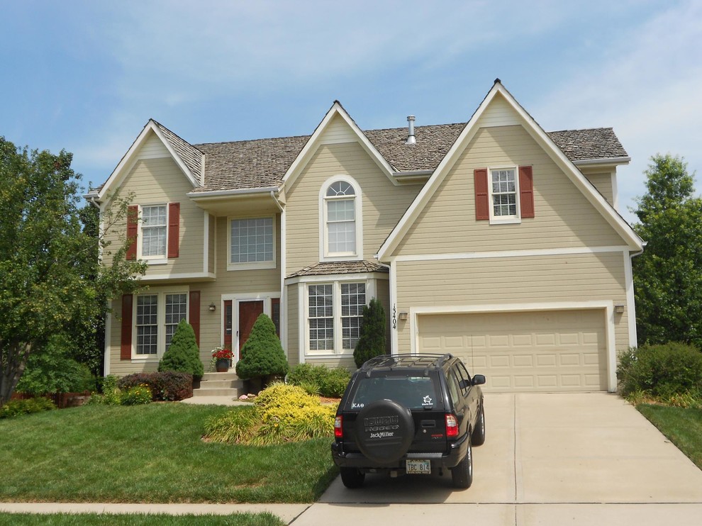 This is an example of a mid-sized two-storey beige exterior in Kansas City with vinyl siding.