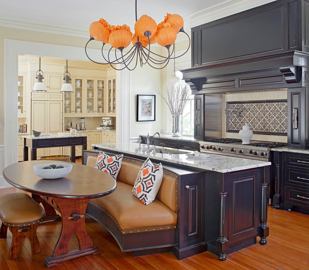 This is an example of an expansive traditional single-wall eat-in kitchen in Charleston with a single-bowl sink, raised-panel cabinets, granite benchtops, beige splashback, ceramic splashback, stainless steel appliances, medium hardwood floors, multiple islands, grey cabinets and beige floor.
