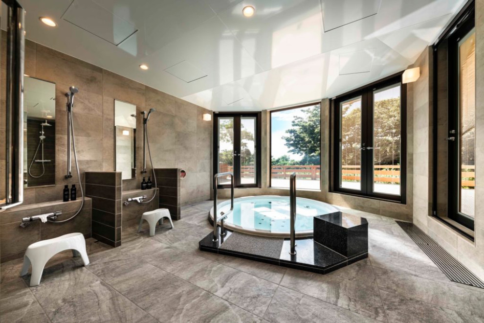 モダンスタイルのおしゃれな浴室 (ドロップイン型浴槽、ベージュの壁、ベージュの床、折り上げ天井) の写真