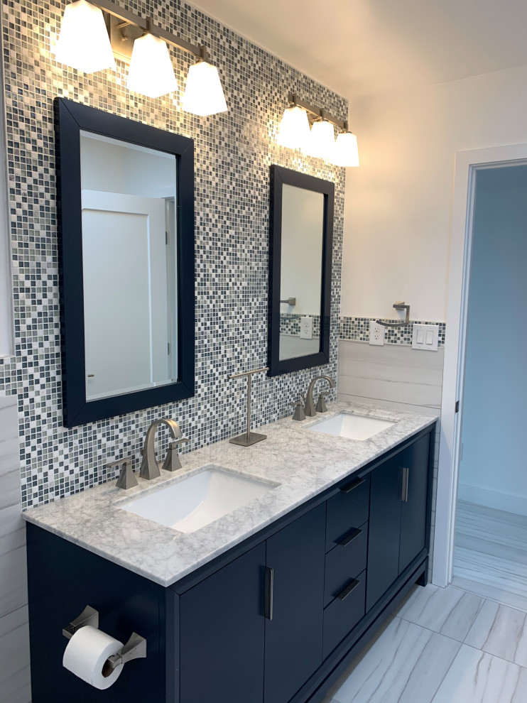 This is an example of a modern kids bathroom with flat-panel cabinets, blue cabinets, gray tile, glass sheet wall, marble benchtops, grey benchtops, a double vanity and a freestanding vanity.