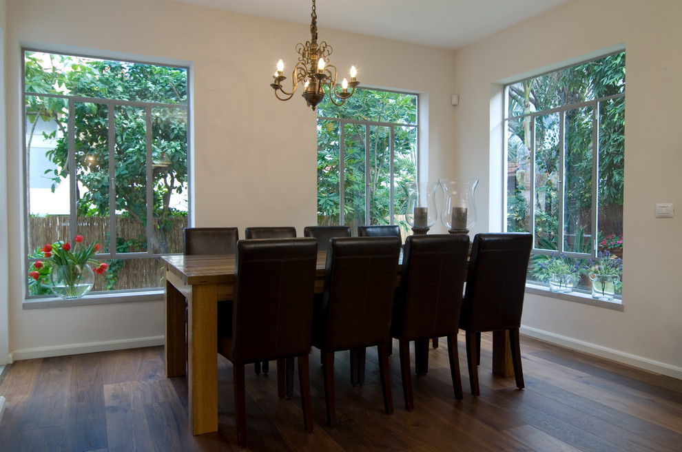 Photo of a contemporary dining room in Tel Aviv with beige walls and dark hardwood floors.