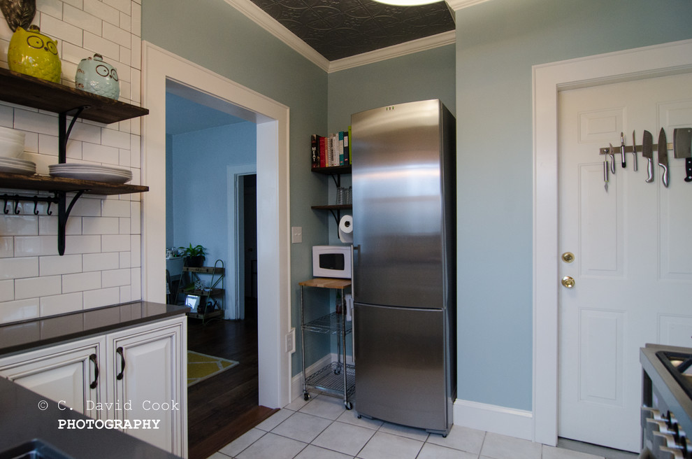 Inspiration for a small transitional u-shaped ceramic tile home design remodel with an undermount sink, raised-panel cabinets, white cabinets, solid surface countertops, white backsplash, subway tile backsplash, stainless steel appliances and no island