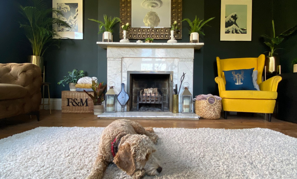 Large victorian grey and yellow enclosed living room in Sussex with green walls, medium hardwood flooring, a standard fireplace, a stone fireplace surround, a built-in media unit, a wallpapered ceiling and a chimney breast.