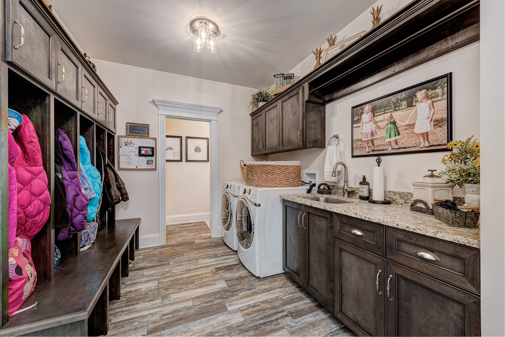 Mid-sized traditional galley utility room in Chicago with an undermount sink, recessed-panel cabinets, dark wood cabinets, beige walls, dark hardwood floors, a side-by-side washer and dryer, brown floor, beige benchtop and granite benchtops.
