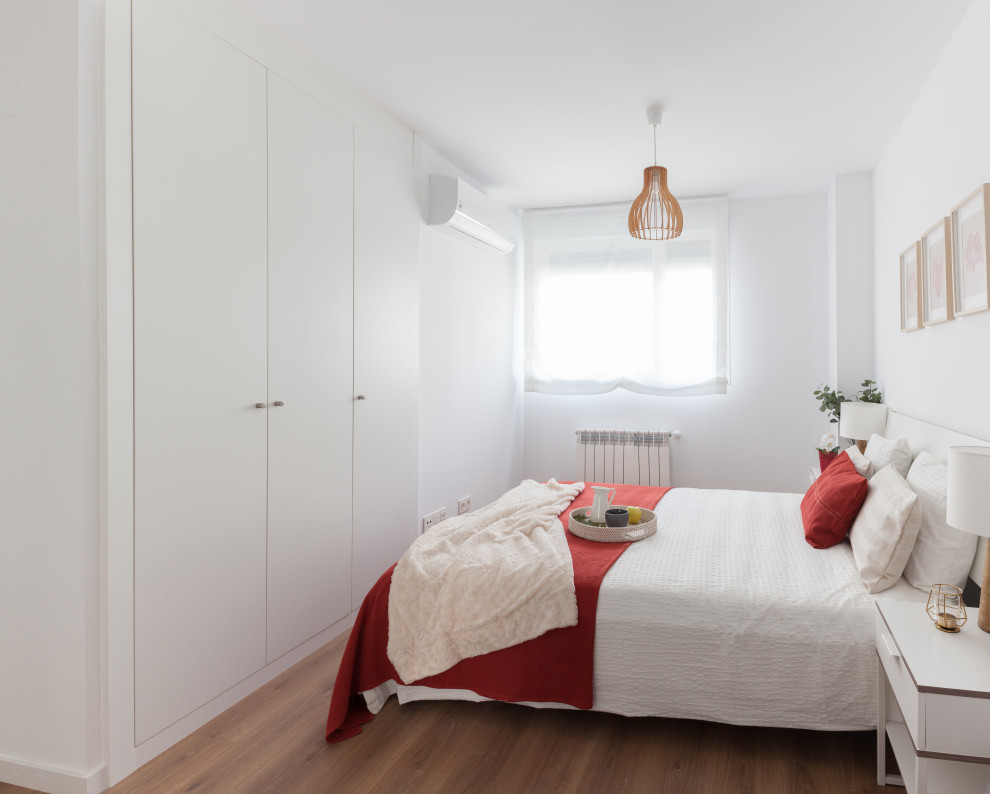 Esempio di una camera matrimoniale scandinava di medie dimensioni con pareti bianche, pavimento in legno massello medio e pavimento marrone