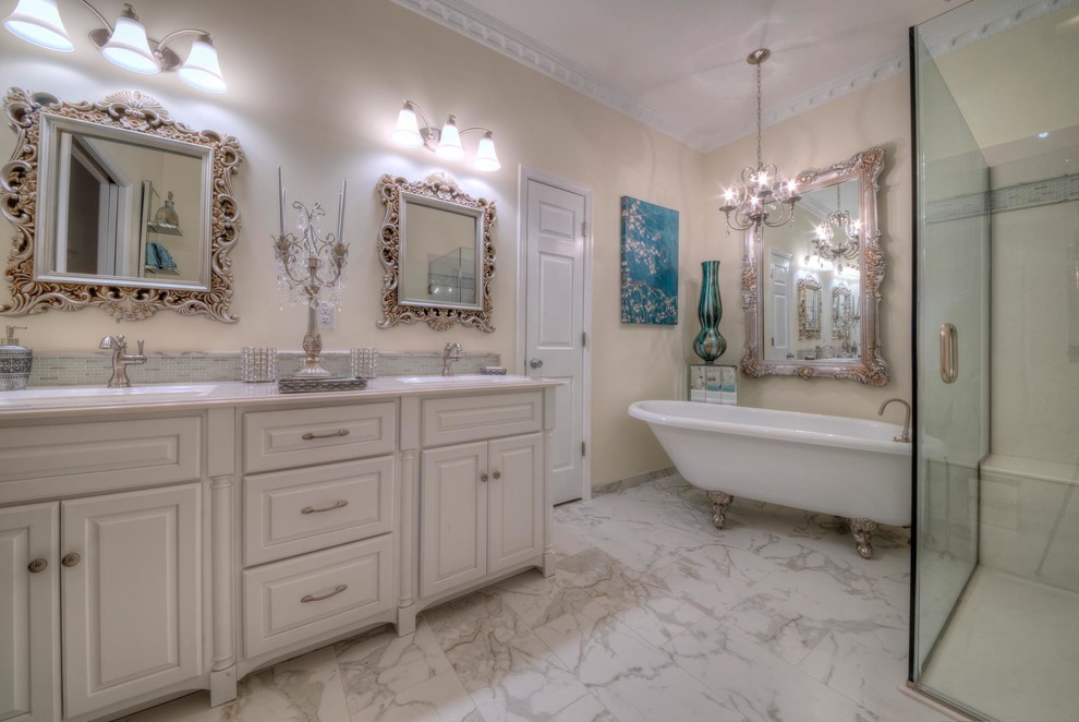 This is an example of a large traditional master bathroom in St Louis with raised-panel cabinets, white cabinets, a freestanding tub, a curbless shower, a two-piece toilet, yellow walls, porcelain floors, an integrated sink, onyx benchtops, multi-coloured floor and a hinged shower door.