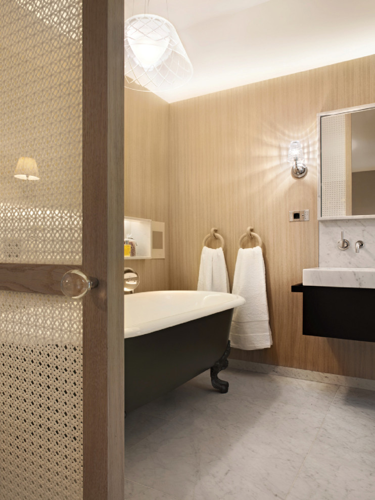Photo of a contemporary bathroom in Milan with a claw-foot bath, marble flooring, marble worktops and wainscoting.