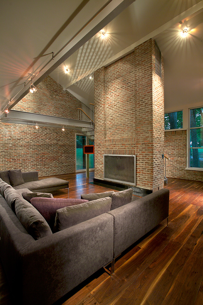 This is an example of a contemporary open concept family room in Other with beige walls, dark hardwood floors, a standard fireplace and a brick fireplace surround.