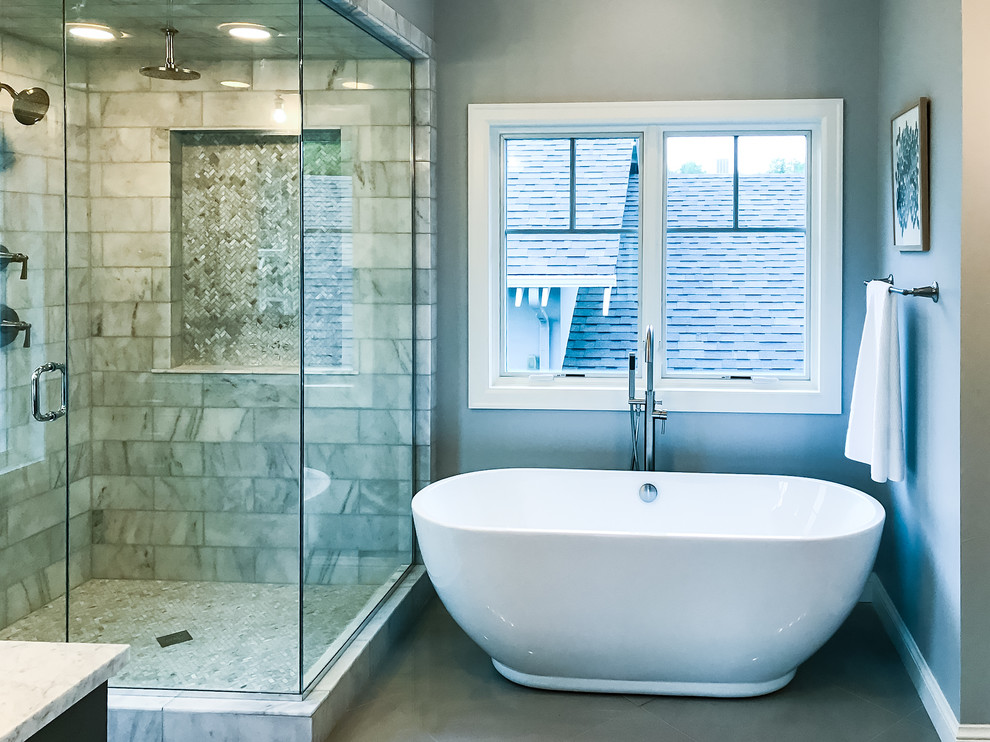 Example of a mid-sized transitional master multicolored tile and stone tile gray floor freestanding bathtub design in Denver with dark wood cabinets, beige walls, marble countertops and a hinged shower door