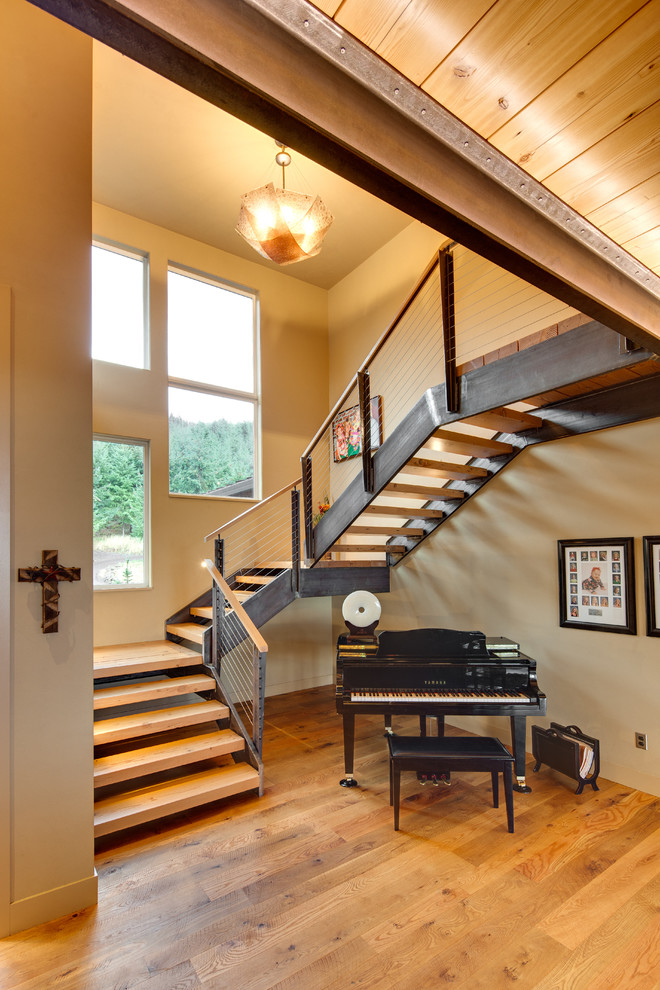 Photo of a large transitional wood u-shaped staircase in Other with metal risers.