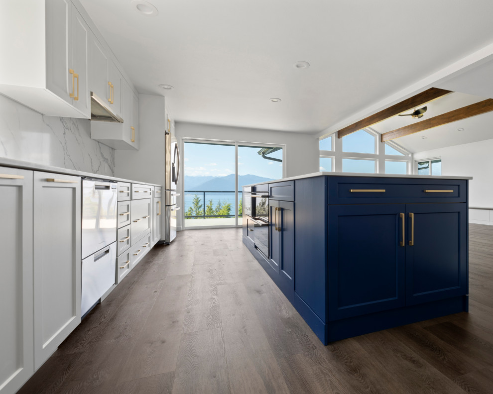 Open concept kitchen - large transitional single-wall vinyl floor, brown floor and vaulted ceiling open concept kitchen idea in Seattle with an undermount sink, shaker cabinets, white cabinets, quartz countertops, white backsplash, quartz backsplash, stainless steel appliances, an island and white countertops