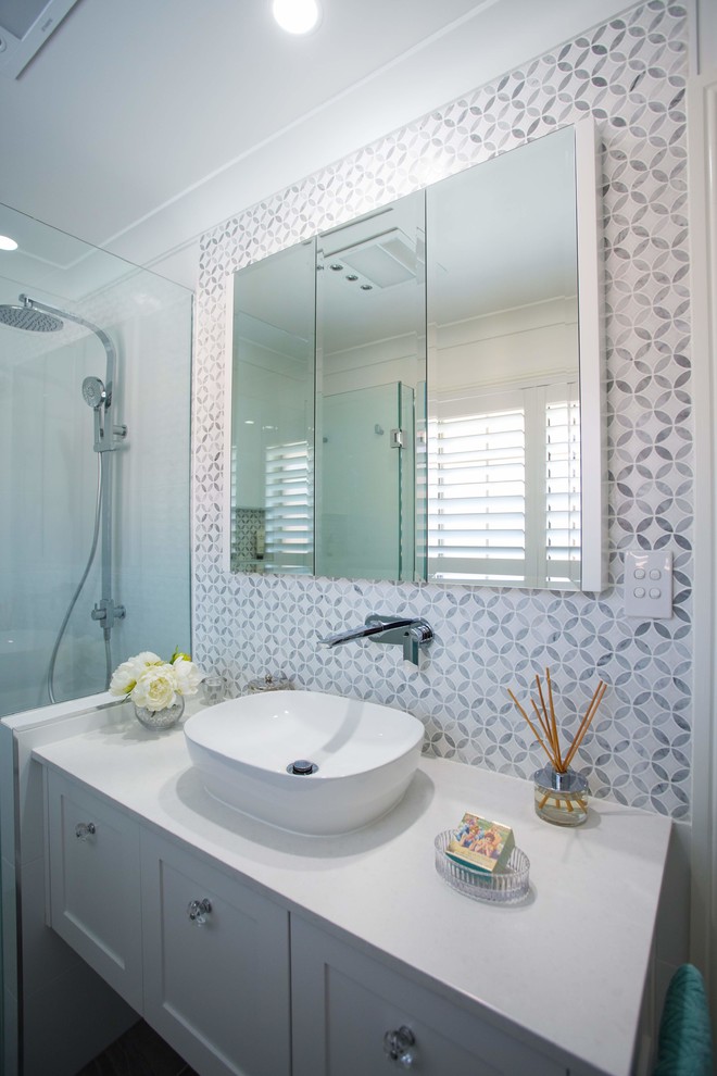 Inspiration for a small traditional 3/4 bathroom in Brisbane with shaker cabinets, white cabinets, an open shower, gray tile, ceramic tile, white walls, ceramic floors, a vessel sink, engineered quartz benchtops, grey floor and white benchtops.