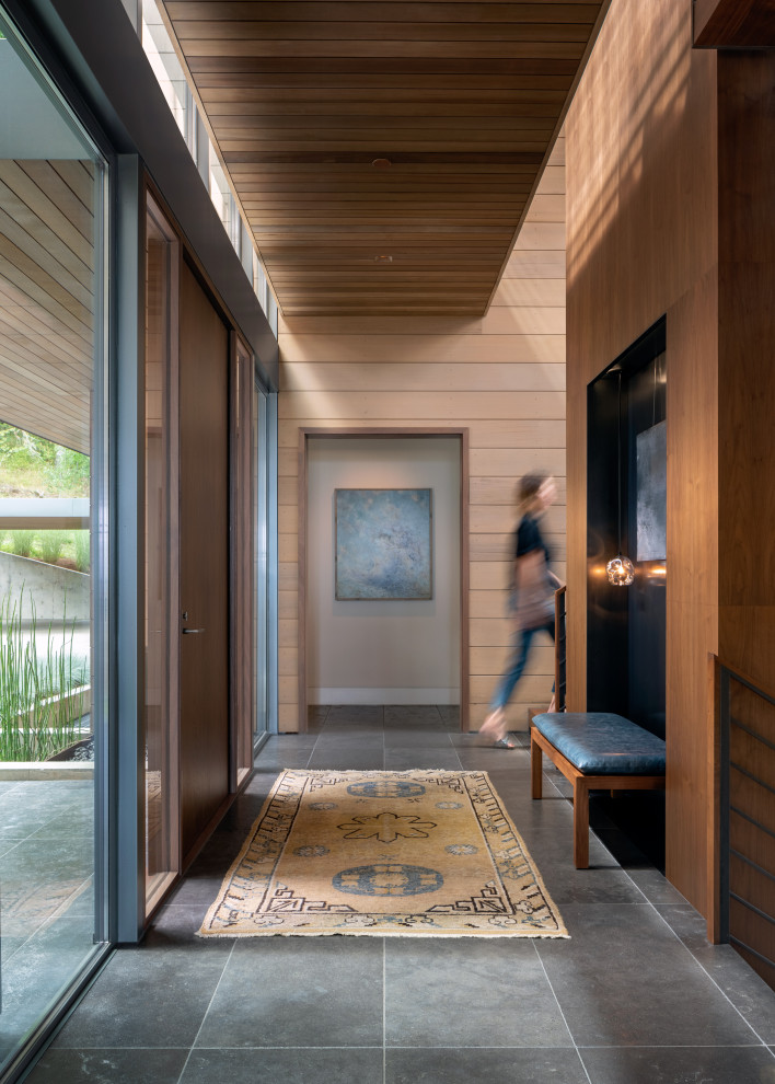 Esempio di un ingresso o corridoio minimalista con una porta singola, soffitto in legno e pareti in legno