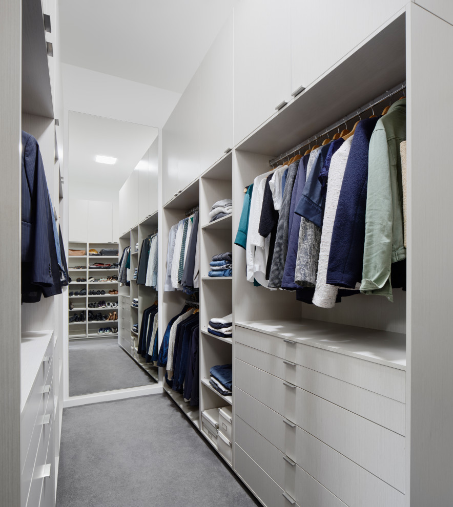 Inspiration for a mid-sized contemporary gender-neutral walk-in wardrobe in Melbourne with flat-panel cabinets, grey cabinets, carpet and grey floor.