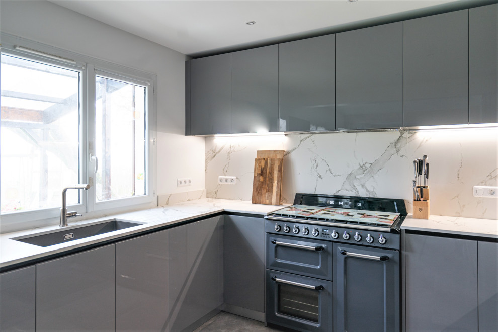 Photo of a large modern galley open plan kitchen in Other with an integrated sink, recessed-panel cabinets, grey cabinets, marble benchtops, white splashback, marble splashback, panelled appliances, cement tiles, with island, grey floor and white benchtop.