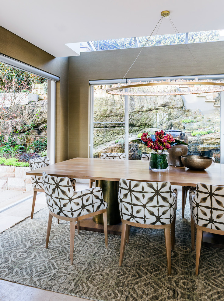 This is an example of a large transitional open plan dining in Sydney with limestone floors, beige floor and green walls.