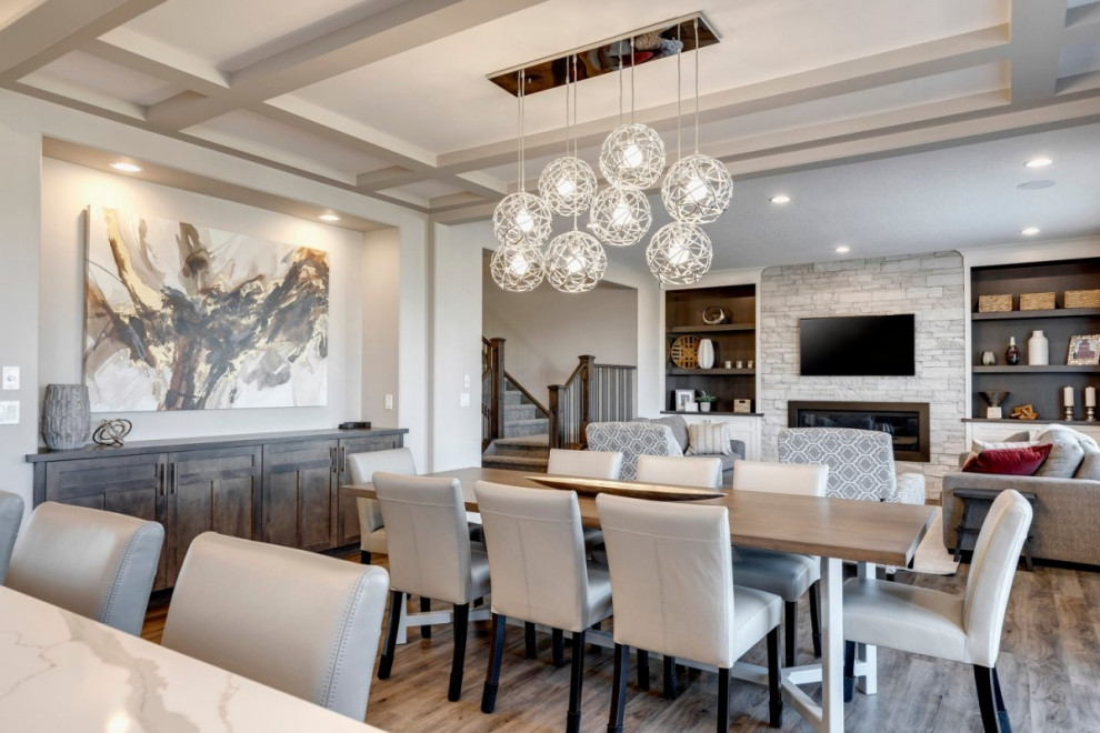 Design ideas for a large traditional open plan dining in Calgary with white walls, medium hardwood floors, a ribbon fireplace, a stone fireplace surround, brown floor and coffered.