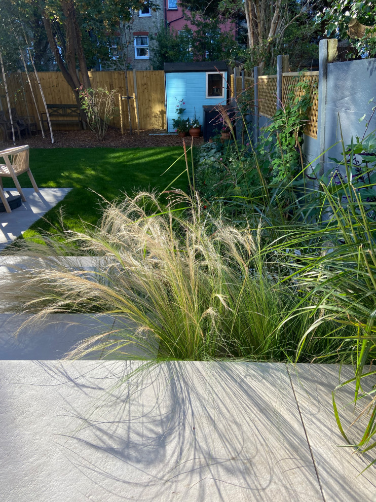 Immagine di un piccolo giardino xeriscape minimal esposto a mezz'ombra dietro casa in estate con scale e pavimentazioni in pietra naturale