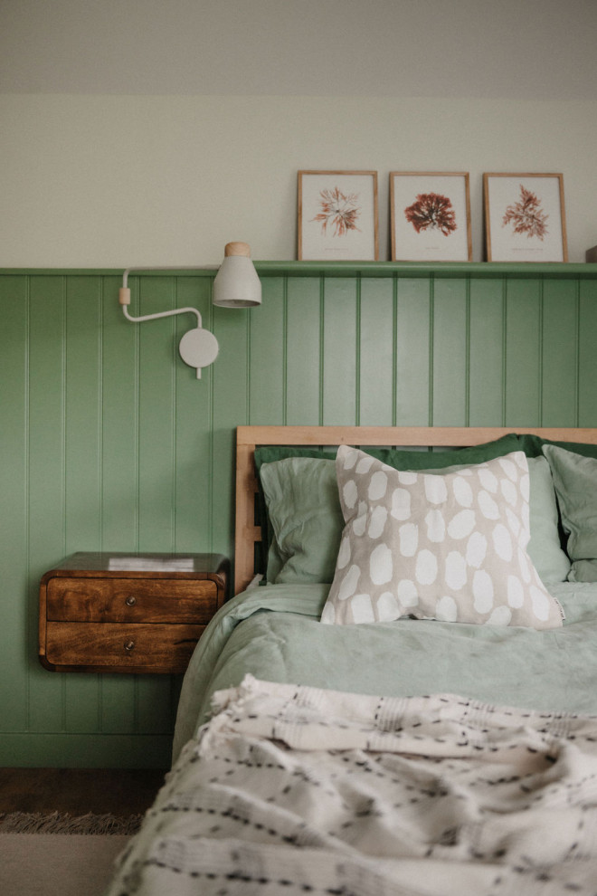 This is an example of a medium sized scandi master bedroom in Cornwall with green walls, cork flooring and a feature wall.