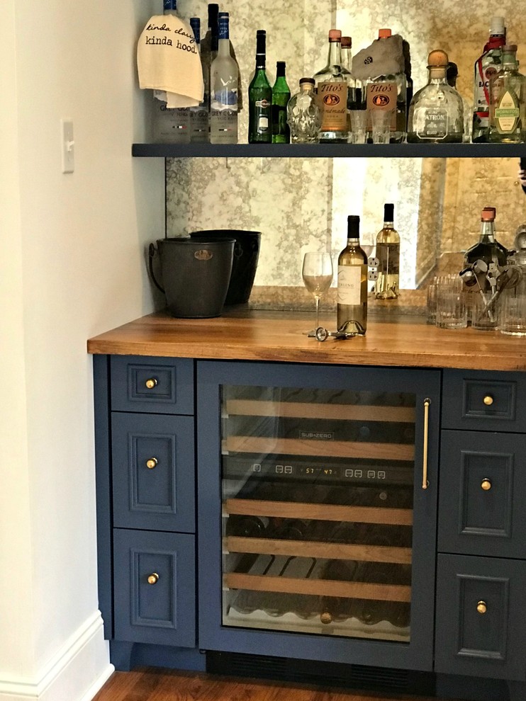 Small transitional single-wall wet bar in Philadelphia with no sink, beaded inset cabinets, blue cabinets, wood benchtops, mirror splashback, medium hardwood floors, brown floor and brown benchtop.