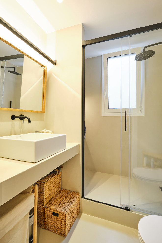 Photo of a medium sized mediterranean ensuite wet room bathroom in Barcelona with open cabinets, beige cabinets, a wall mounted toilet, beige tiles, beige walls, concrete flooring, a vessel sink, concrete worktops, beige floors, a sliding door, beige worktops, a wall niche, a single sink and a built in vanity unit.
