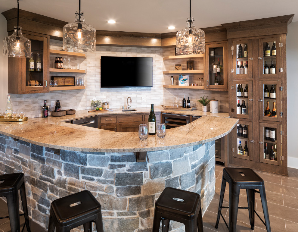 Inspiration for a beach style u-shaped seated home bar in Minneapolis with an undermount sink, glass-front cabinets, dark wood cabinets, grey splashback, brown floor and brown benchtop.