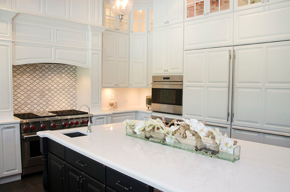 Large transitional u-shaped enclosed kitchen photo in Miami with a farmhouse sink, raised-panel cabinets, white cabinets, quartz countertops, gray backsplash, porcelain backsplash, paneled appliances and an island