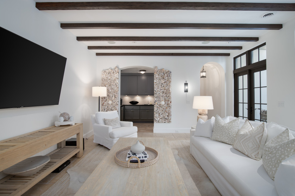 Ejemplo de sala de estar cerrada costera de tamaño medio con paredes blancas, televisor colgado en la pared y vigas vistas
