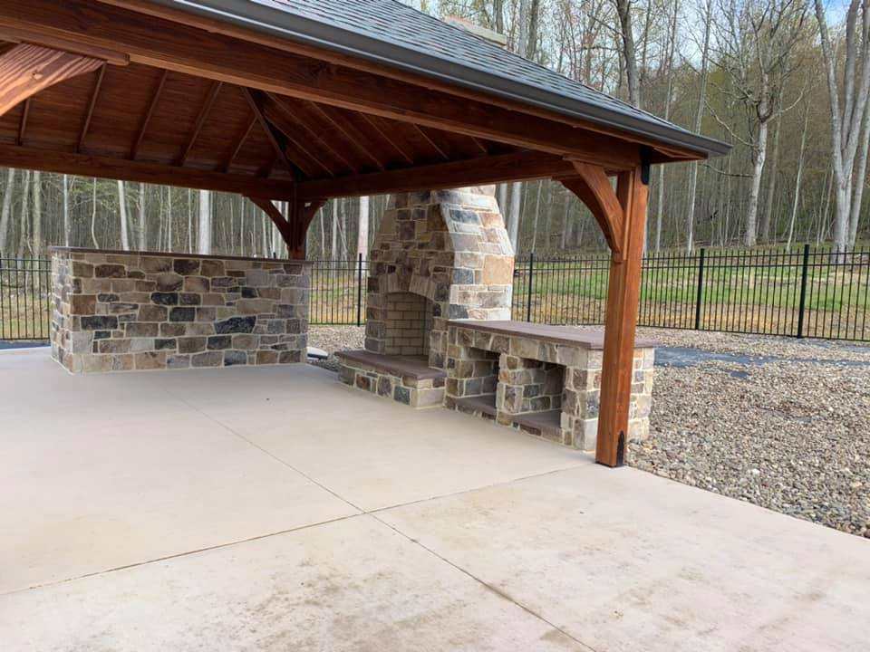 This is an example of a large traditional backyard patio in Other with with fireplace, concrete slab and a gazebo/cabana.