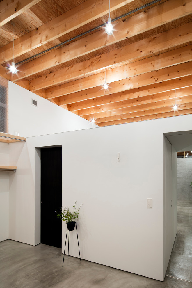 Источник вдохновения для домашнего уюта: хозяйская спальня: освещение в стиле лофт с бетонным полом, балками на потолке и обоями на стенах