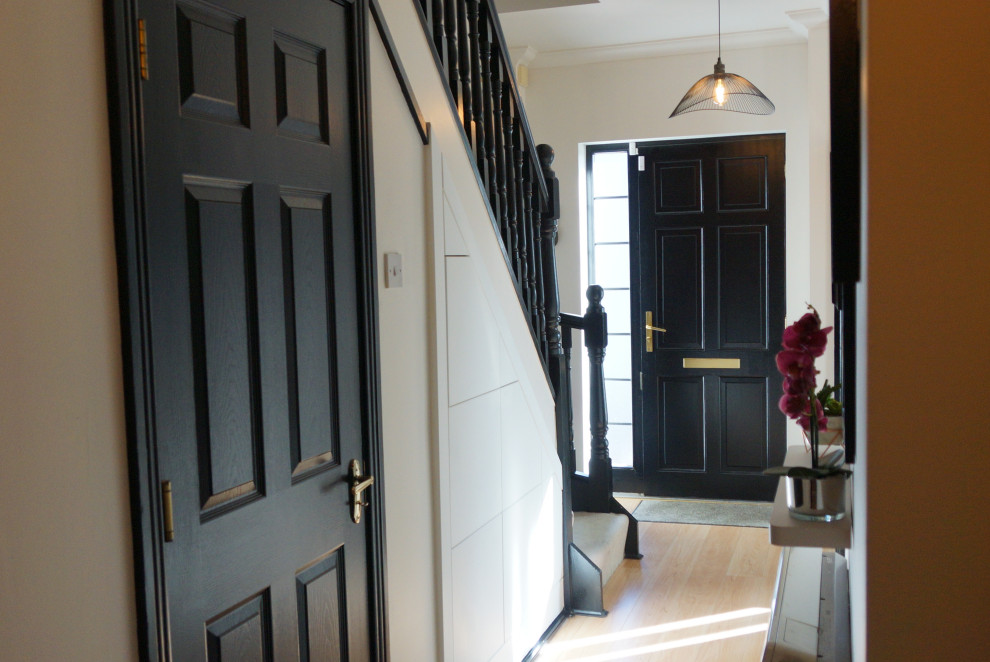Immagine di un piccolo ingresso o corridoio design con pareti bianche, pavimento in laminato e pavimento marrone