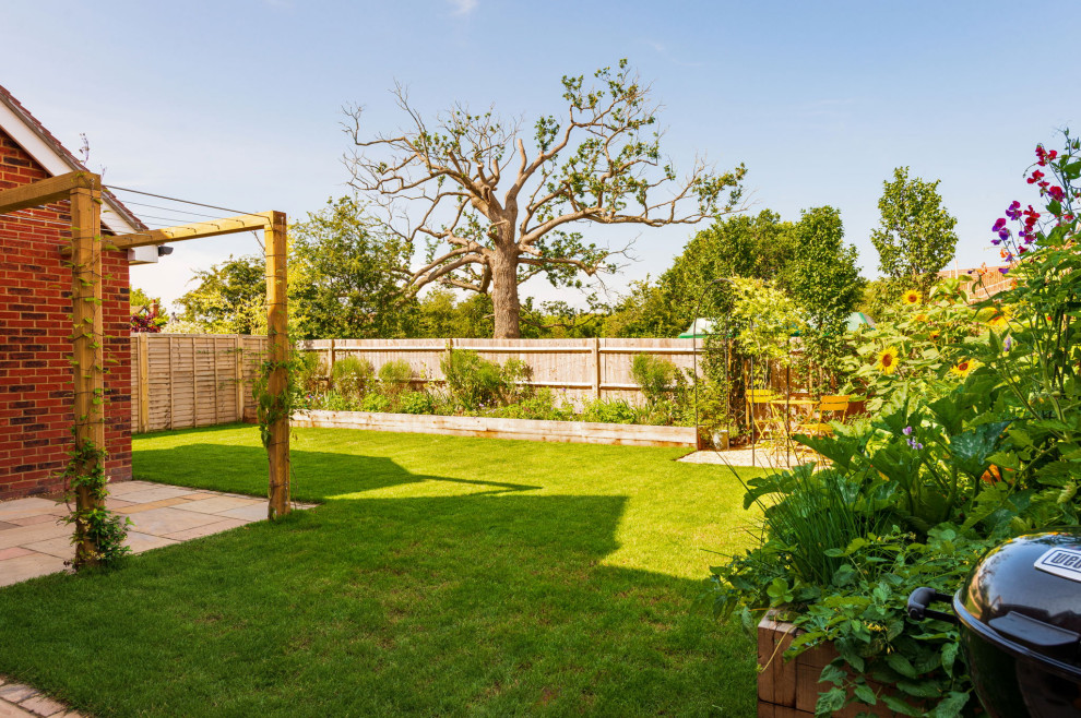 Esempio di un piccolo giardino country esposto a mezz'ombra dietro casa con pavimentazioni in pietra naturale e recinzione in legno