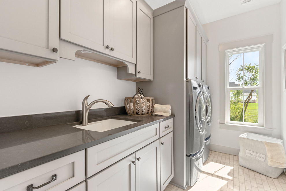 Photo of a country galley utility room in Columbus with an undermount sink, shaker cabinets, beige cabinets, white walls, a side-by-side washer and dryer, beige floor and brown benchtop.