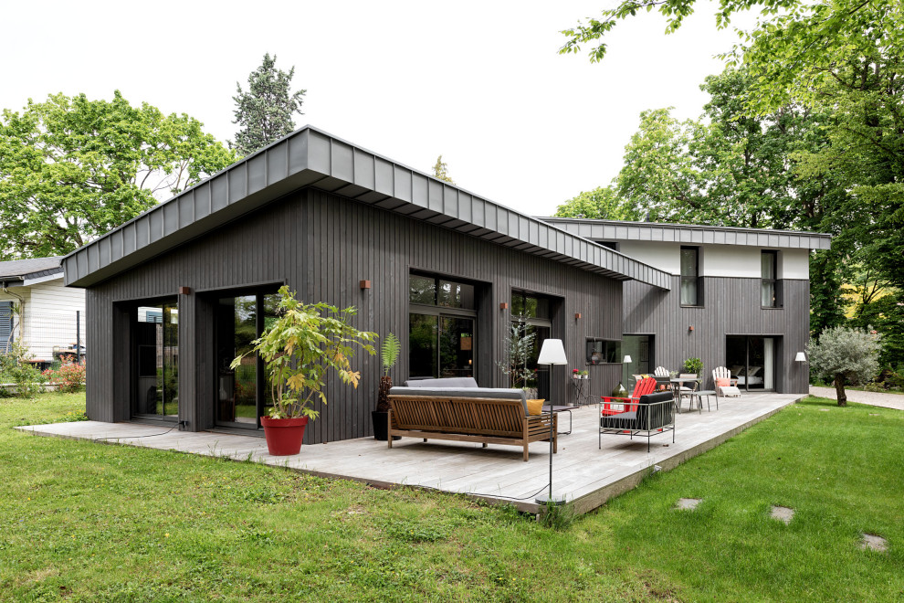 Design ideas for an expansive contemporary two-storey grey house exterior in Paris with wood siding, a shed roof, a metal roof, a grey roof and clapboard siding.
