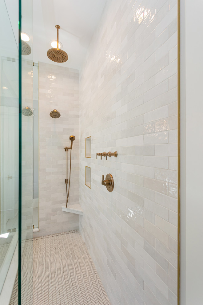 Photo of a large beach style ensuite bathroom in Charleston with shaker cabinets, light wood cabinets, a freestanding bath, a walk-in shower, a two-piece toilet, grey tiles, metro tiles, white walls, porcelain flooring, a submerged sink, marble worktops, white floors, an open shower, white worktops, a wall niche, double sinks and a built in vanity unit.