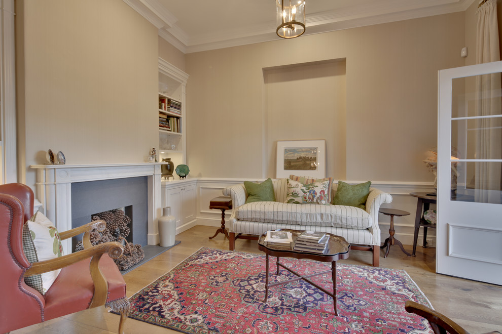 This is an example of a mid-sized traditional formal open concept living room in Melbourne with a standard fireplace, a wood fireplace surround, beige floor, beige walls and light hardwood floors.