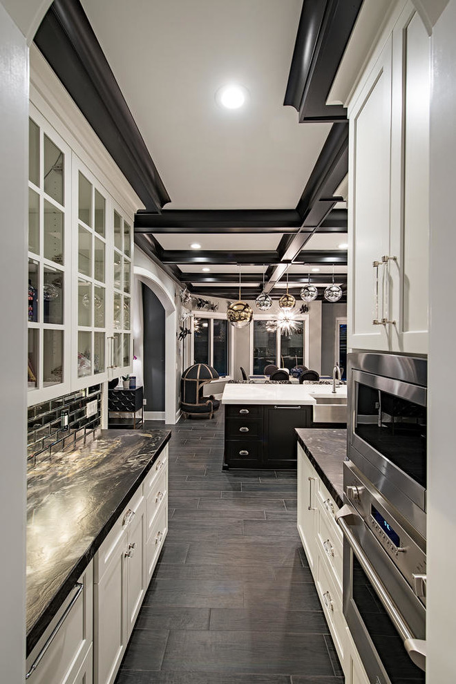 Inspiration for an expansive transitional l-shaped eat-in kitchen in Cleveland with a farmhouse sink, shaker cabinets, white cabinets, white splashback, stainless steel appliances, dark hardwood floors, with island and grey floor.