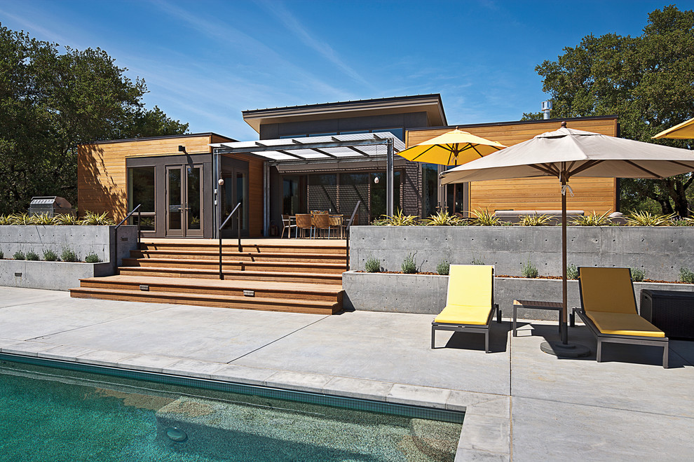Design ideas for a large contemporary backyard rectangular pool in San Francisco with a water feature and decking.
