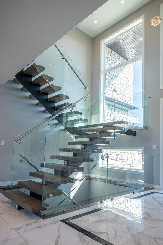 Inspiration for a large modern wood u-shaped staircase in Other with open risers and glass railing.
