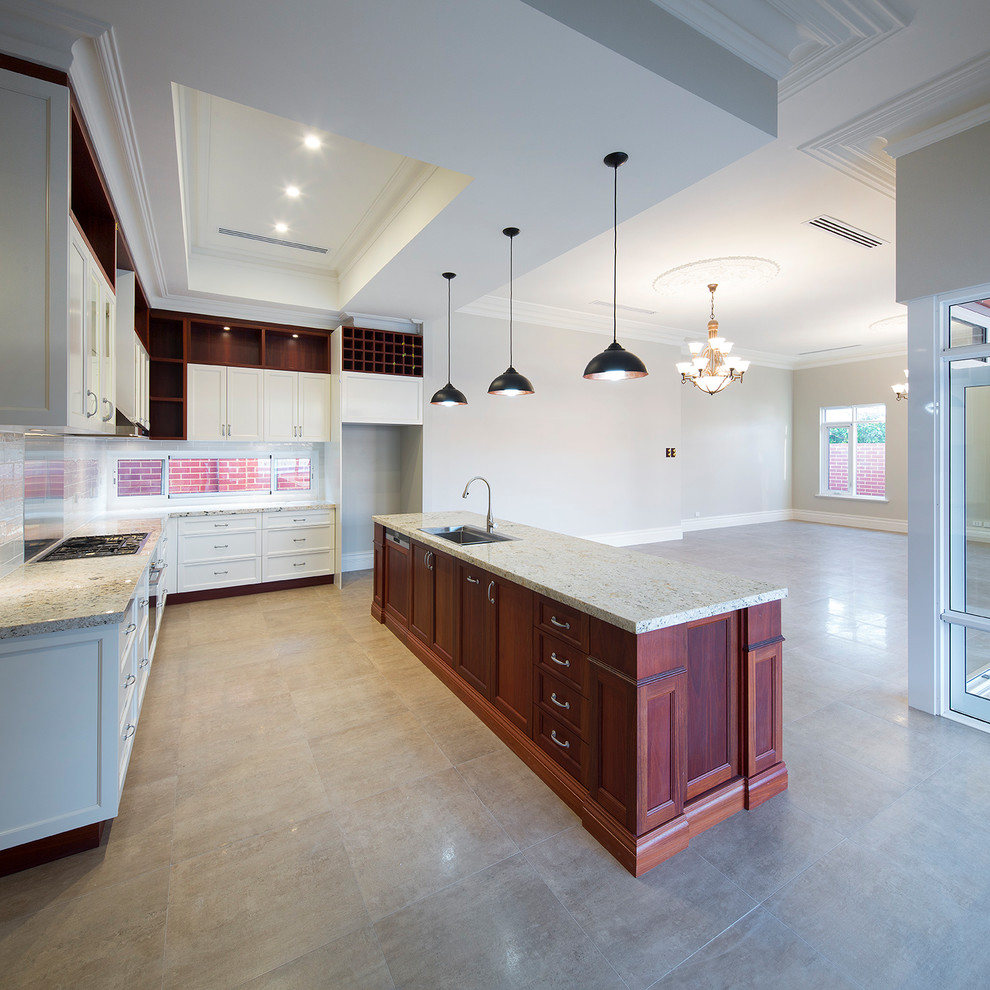 Design ideas for a mid-sized traditional galley open plan kitchen in Perth with a double-bowl sink, shaker cabinets, white cabinets, limestone benchtops, white splashback, subway tile splashback and with island.