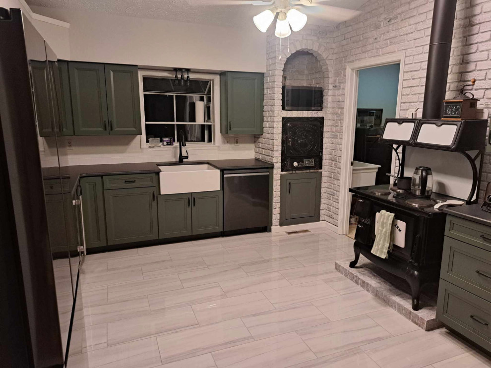 This is an example of a large country u-shaped kitchen in DC Metro with a belfast sink, recessed-panel cabinets, engineered stone countertops, black appliances, porcelain flooring and black worktops.