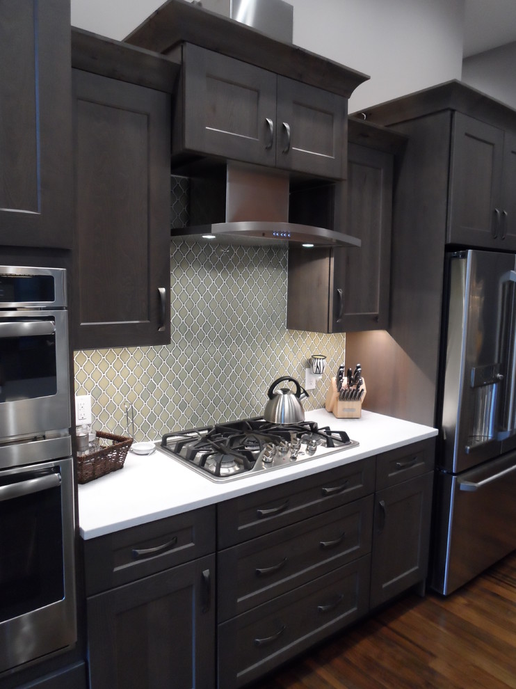 Large transitional galley medium tone wood floor and brown floor open concept kitchen photo in Other with a farmhouse sink, shaker cabinets, dark wood cabinets, quartz countertops, green backsplash, stainless steel appliances, an island and ceramic backsplash