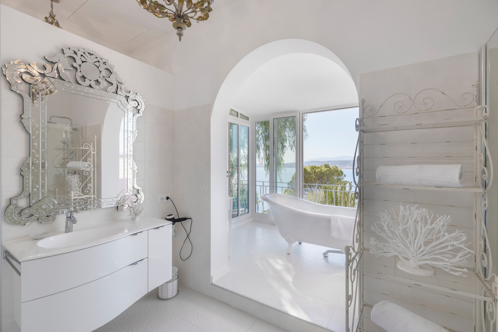 Photo of a contemporary bathroom in Nice with flat-panel cabinets, white cabinets, a claw-foot tub, white tile, white walls, an integrated sink, white floor and white benchtops.