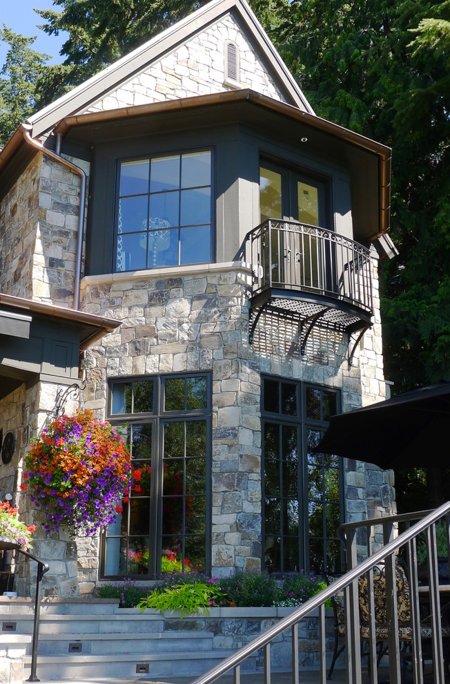 Design ideas for an expansive traditional two-storey beige exterior in Seattle with stone veneer and a gable roof.