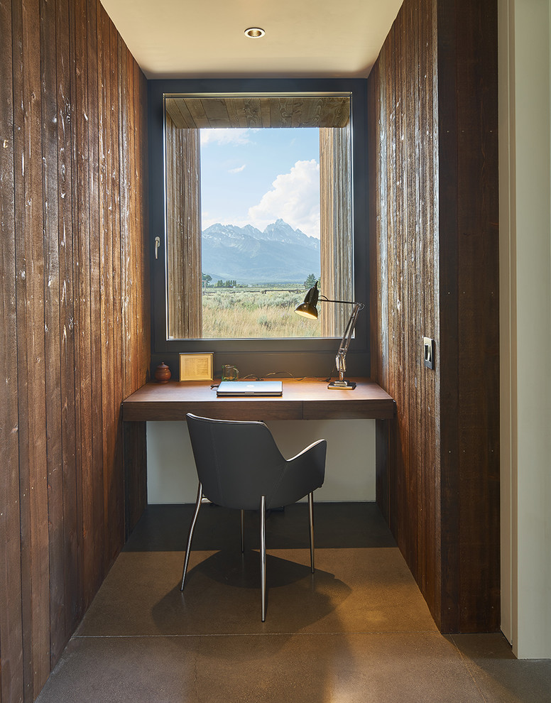 Mid-sized modern study room in Denver with brown walls, concrete floors, a built-in desk and brown floor.
