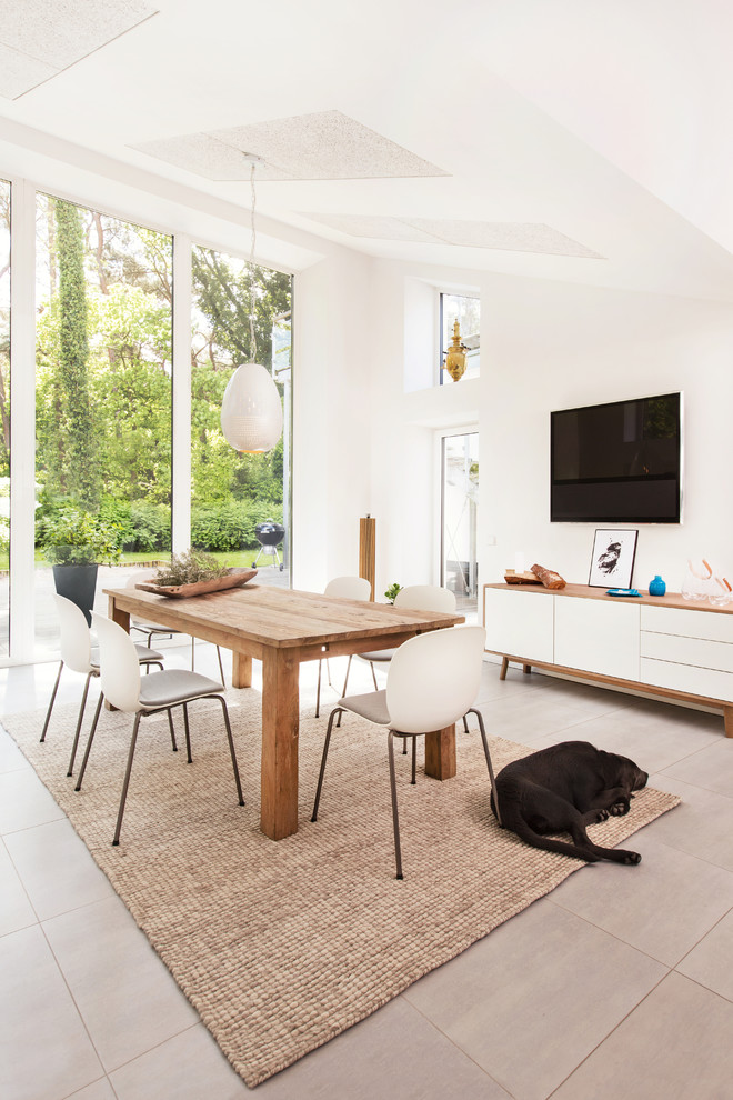 This is an example of a large contemporary open plan dining in Hamburg with white walls and no fireplace.