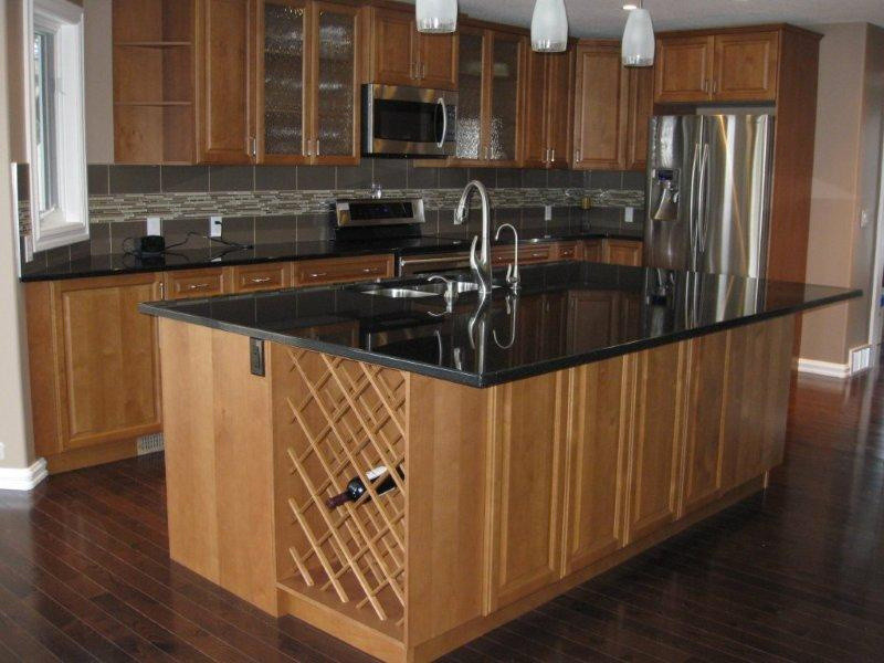 Photo of a mid-sized traditional l-shaped kitchen in Calgary with a double-bowl sink, raised-panel cabinets, light wood cabinets, granite benchtops, stainless steel appliances, dark hardwood floors and with island.